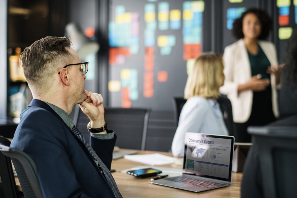 Professional listening during a presentation in a meeting room.
